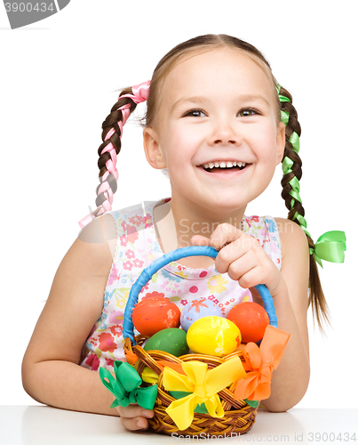Image of Little girl with basket full of colorful eggs
