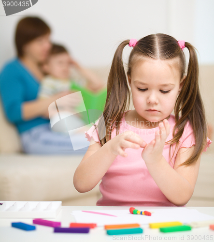 Image of Little girl is playing with plasticine