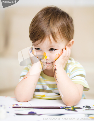 Image of Little boy is playing with paints