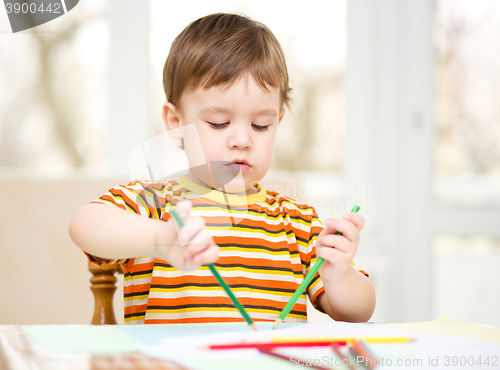 Image of Little boy is drawing on white paper