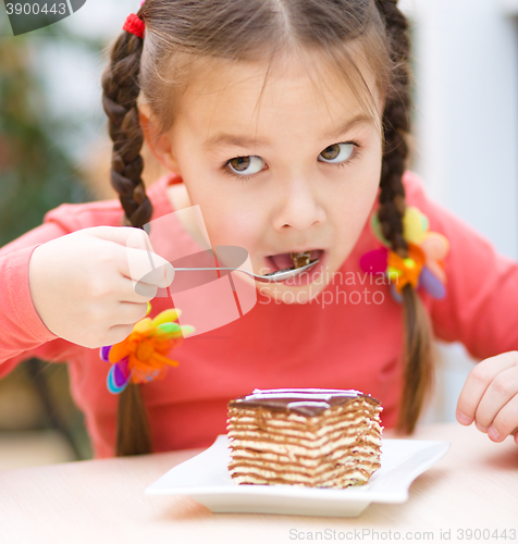 Image of Little girl is eating cake in parlor