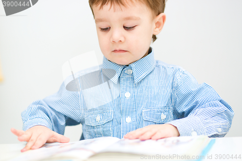 Image of Little boy is reading book