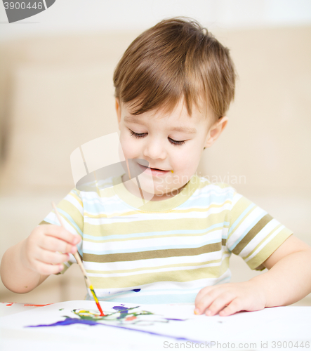 Image of Little boy is playing with paints