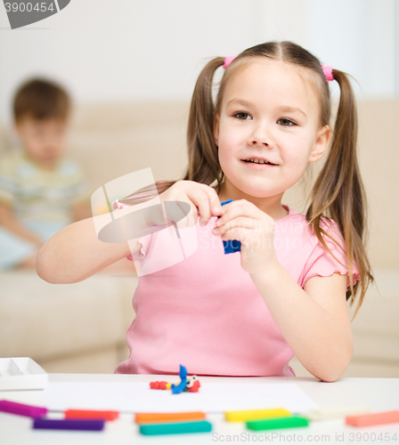 Image of Little girl is playing with plasticine