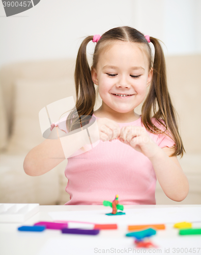 Image of Little girl is playing with plasticine