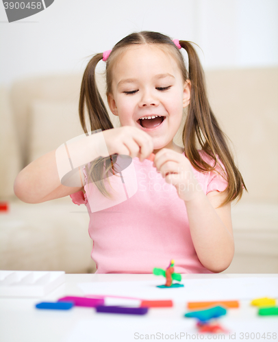 Image of Little girl is playing with plasticine