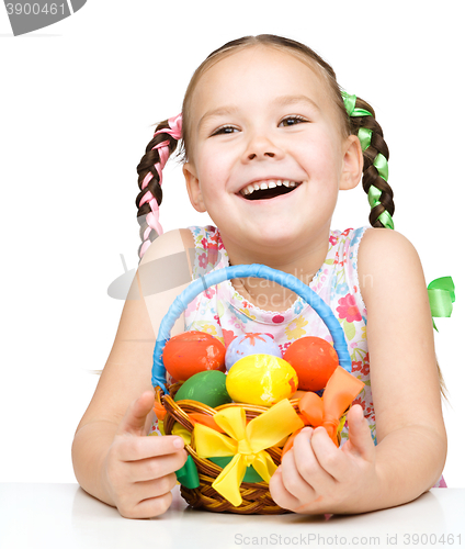 Image of Little girl with basket full of colorful eggs