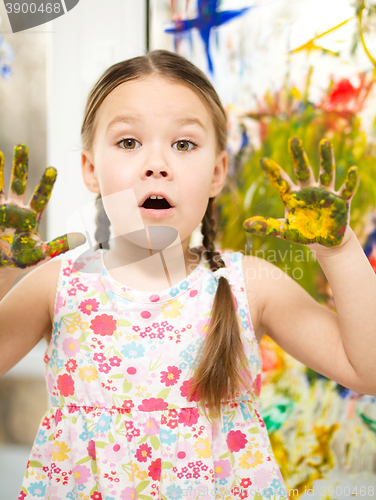 Image of Portrait of a cute girl playing with paints