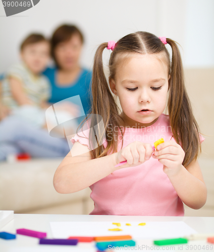 Image of Little girl is playing with plasticine