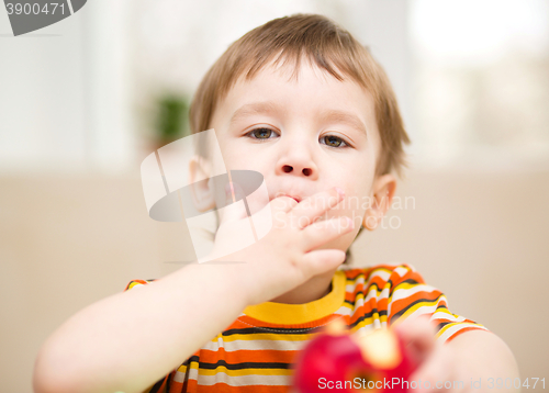 Image of Little boy is eating apple