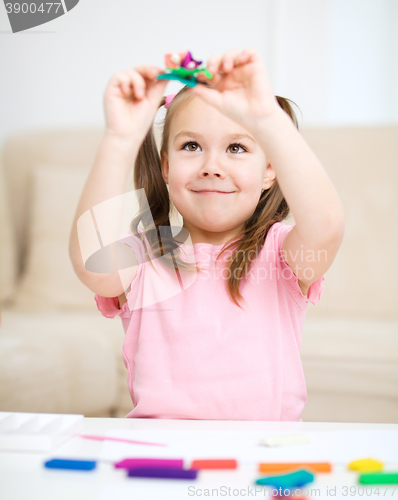 Image of Little girl is playing with plasticine