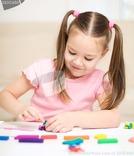 Image of Little girl is playing with plasticine