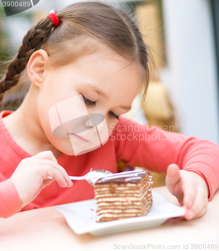 Image of Little girl is eating cake in parlor