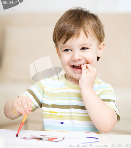 Image of Little boy is playing with paints