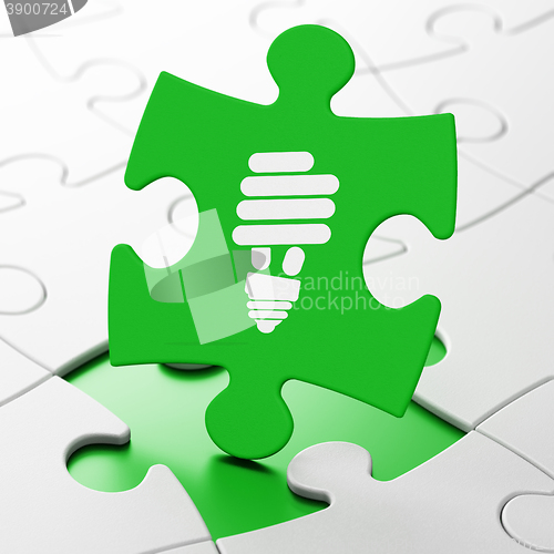 Image of Business concept: Energy Saving Lamp on puzzle background