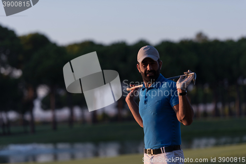 Image of golfer  portrait at golf course on sunset
