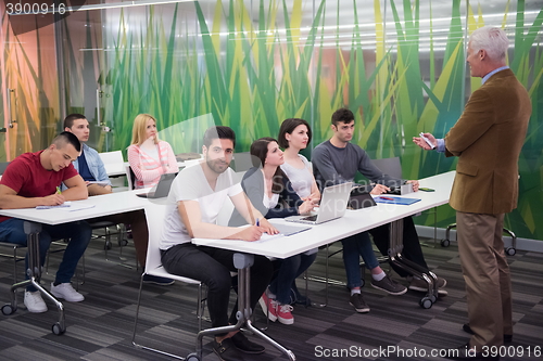 Image of teacher with a group of students in classroom