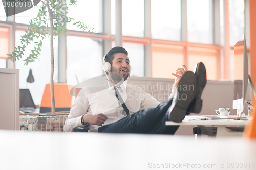 Image of relaxed young business man at office