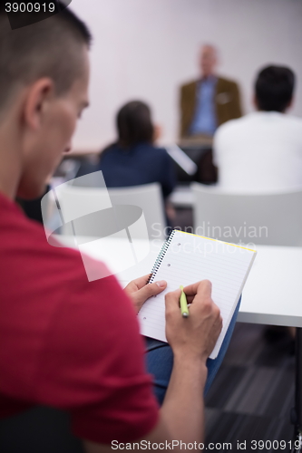 Image of male student taking notes in classroom