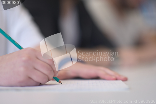 Image of male student taking notes in classroom