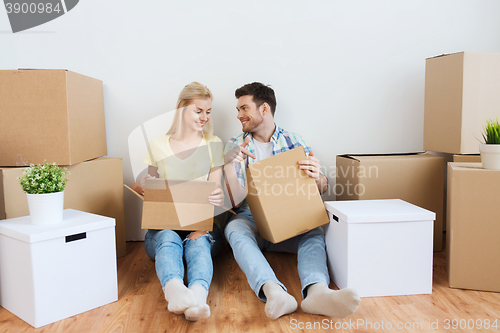 Image of smiling couple with many boxes moving to new home