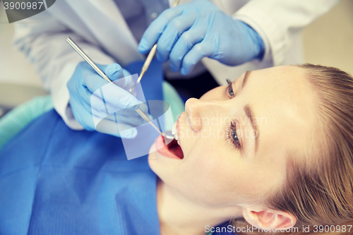 Image of close up of dentist checking female patient teeth