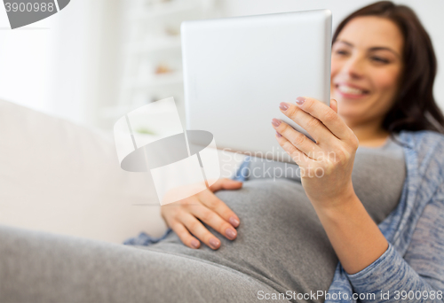 Image of close up of pregnant woman with tablet pc at home