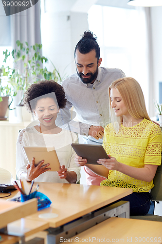 Image of happy creative team with tablet pc in office