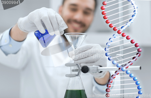 Image of close up of scientist with test tubes and funnel