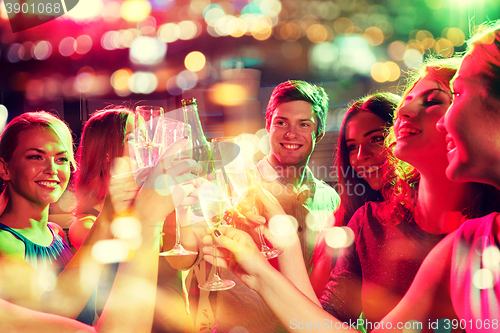 Image of smiling friends with wine glasses and beer in club