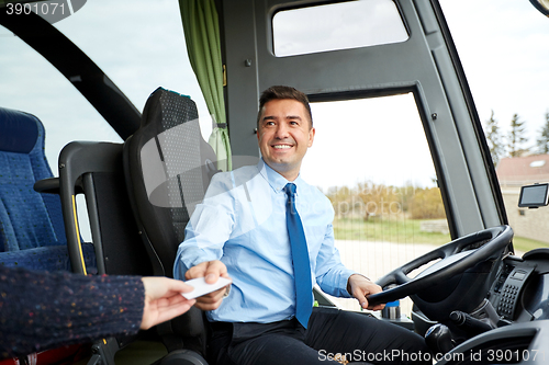 Image of bus driver taking ticket or card from passenger