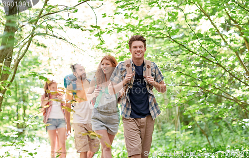 Image of group of smiling friends with backpacks hiking