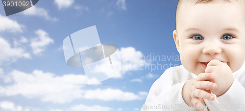 Image of happy baby face over blue sky background