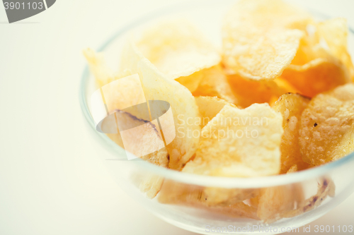 Image of close up of crunchy potato crisps in glass bowl