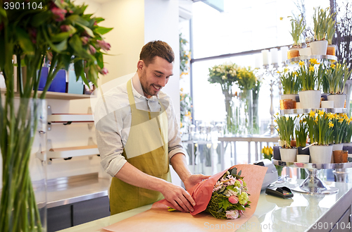 Image of florist wrapping flowers in paper at flower shop