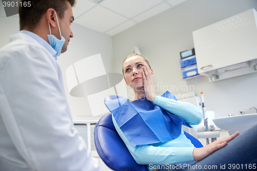 Image of male dentist with woman patient at clinic