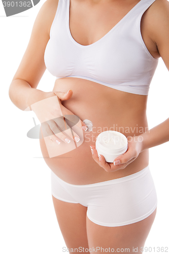 Image of Pregnant woman with cosmetic cream on belly