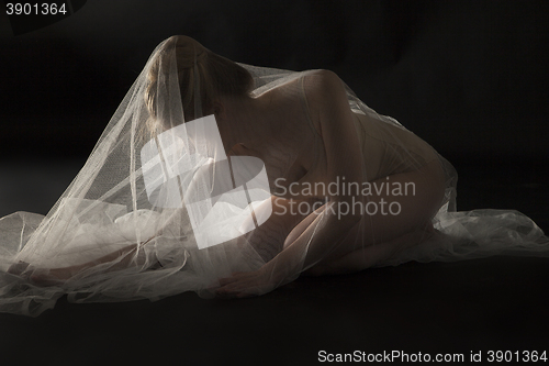 Image of woman under transparent textile over black