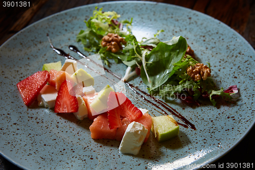 Image of salad with strawberries, salmon, cheese and walnuts