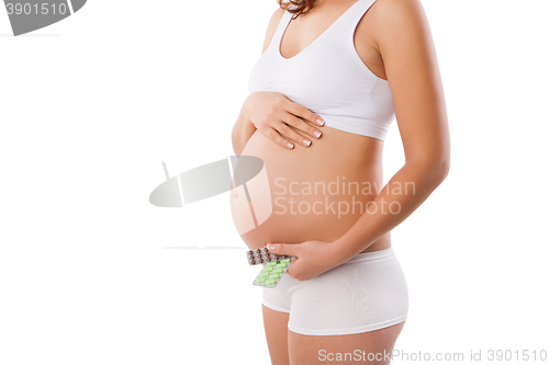 Image of Pregnant woman with medicine tablets in hand