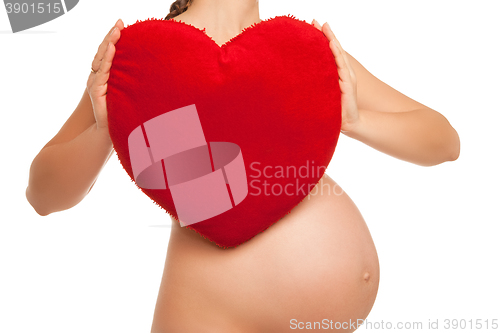 Image of pregnant woman holding  heart symbol over white