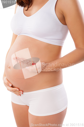 Image of Pregnant woman with medicine tablets in hand