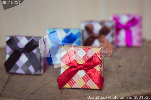 Image of Gift box with red bow on wood background