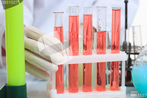 Image of hands holding test tubes with chemical elements. 