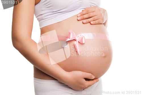 Image of Pregnant woman tummy with pink ribbon over white