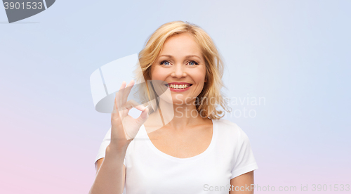 Image of happy woman in white t-shirt showing ok hand sign