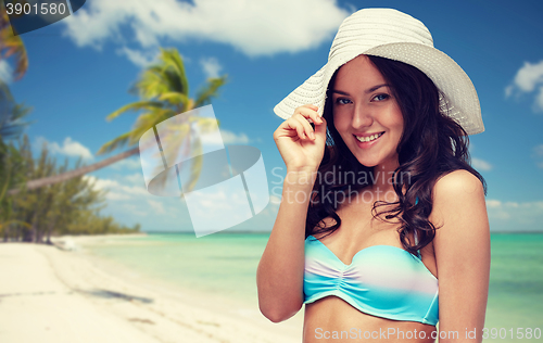 Image of happy young woman in bikini swimsuit and sun hat