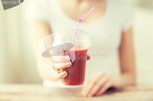 Image of close up of woman holding cup with smoothie