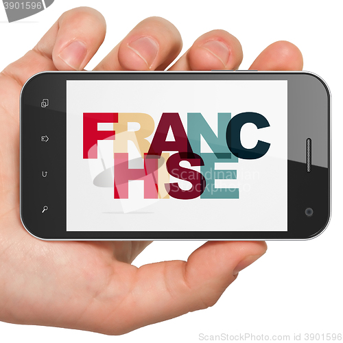 Image of Finance concept: Hand Holding Smartphone with Franchise on  display