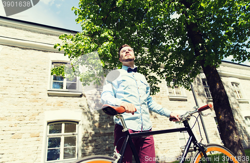 Image of happy young hipster man riding fixed gear bike